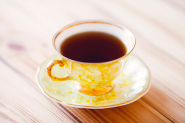 Vintage cup of tea with natural sweets and jar of honey on the wooden background. Sunny morning.  