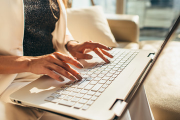 Closeup of woman hands typing on laptop keyboard