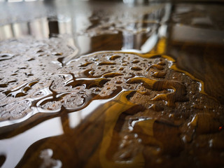 Puddle of water and rain drops on a wooden platform