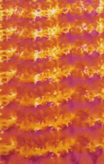 Photograph of a handpainted tie-dye fabric background with bright irregular spors pattern
