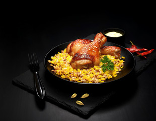 grilled chicken legs with sesame and rice on a black background.