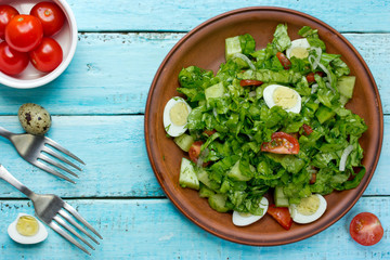 Healthy green salad with cherry tomatoes and quail eggs
