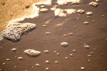 Foam bubbles of the surf on sand