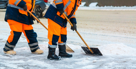 Fototapeta premium Communal services workers sweep snow from road in winter, Cleaning city streets and roads after snow storm. Moscow, Russia.