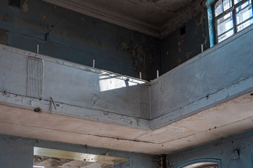 Old abandoned building of the Soviet manufactory. Empty room with columns. Daylight