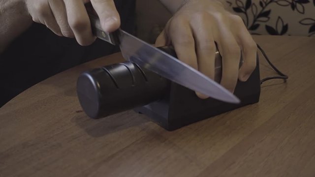 Sharpening a kitchen knife with an electronic sharpener