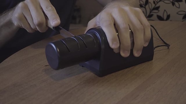 Sharpening a kitchen knife with an electronic sharpener