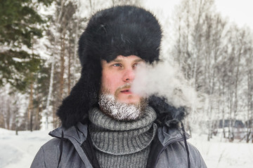 frozen man with a beard in winter in a forest with snowdrifts fell ill from the cold after a walk...