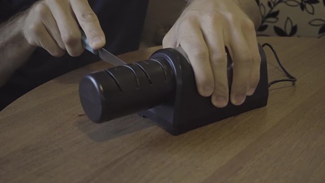 Sharpening a kitchen knife with an electronic sharpener