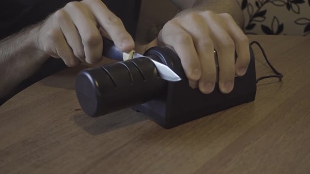 Sharpening a kitchen knife with an electronic sharpener