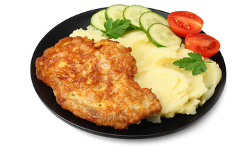 Mashed potatoes with schnitzel on black plate isolated on white background.