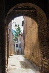 Narrow street seen through an arch in Gubbio town