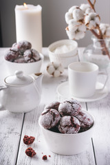 Red velvet cookies on a white table, white cups