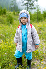 little boy in the woods with a backpack