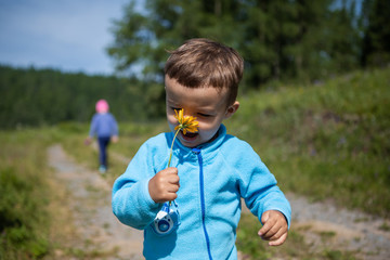 boy sniffing a flower