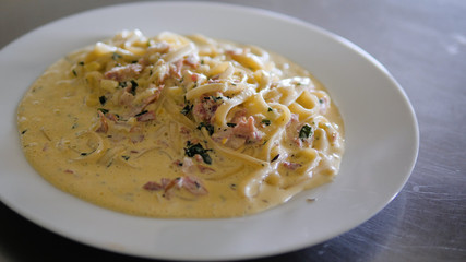 italian food spaghetti carbonara with sauce in a plate