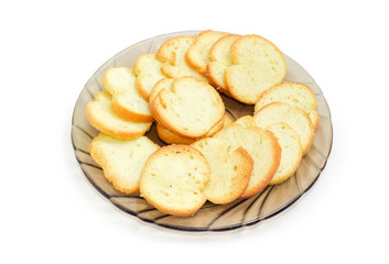 Spicy rusks on the glass saucer on a white background
