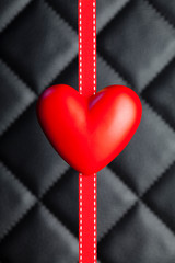 Red heart and ribbon on black background