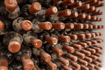 Wine aging process. Wine bottles aging, covered in dust and mold, in a traditional winery