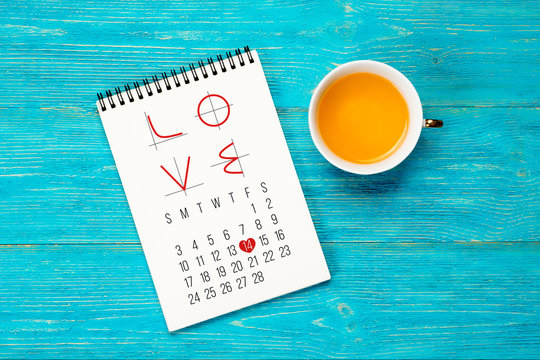 LOVE text with math charts in notepad over wooden turquoise planks, february 2019 month calendar