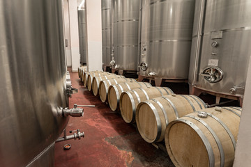 Interior of a winery making wine in oak barrels and aluminium tanks
