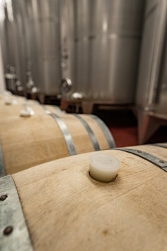 Inside of a modern winery having wine in oak barrels and aluminium tanks