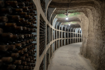 Underground wine cellar with aging wine bottles in racks