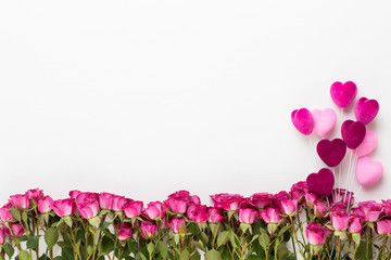 Flowers composition. Frame made of red rose on white wooden background. Flat lay, top view, copy...