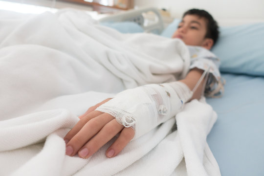 Little boy get sick from influenza need to be admitted to hospital with saline intravenous (iv)  in-line hand pressure