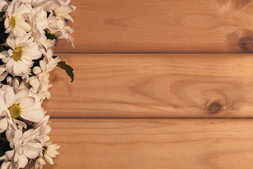 beautiful white of daisies on a wooden background with copy space