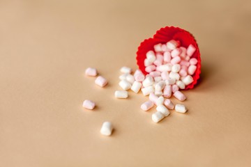 Red heart shape with marshmallows on beige background. Valentine's Day. Love. Holiday.