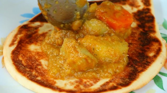 Topping Kari curry on plain nan, Indian food