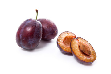 Group of whole and half of ripe plums isolated on a white background..