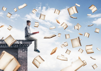 Man reading book and many of them flying in air