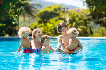 Fototapeta na wymiar Family in swimming pool. Kids swim. Summer fun.