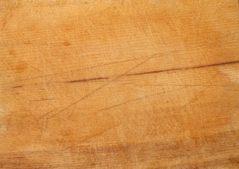 Wood texture. The surface of brown scratched wooden cutting board. Grunge textured wooden background.