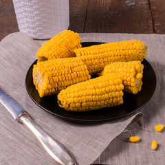 Cooked corn on a plate over old wooden table