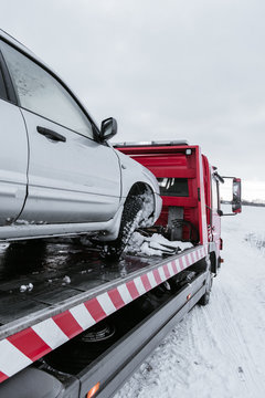 Car on tow truck on snow road