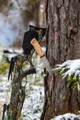  hunting tourist crossbow, a knife stuck in a pine against the background of a winter forest
