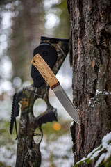  hunting tourist crossbow, a knife stuck in a pine against the background of a winter forest