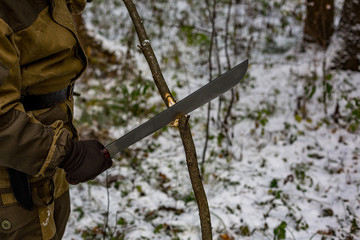 the hunter in the winter forest gets a big knife