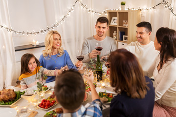 celebration, holidays and people concept - happy family having dinner party, drinking red wine and toasting at home