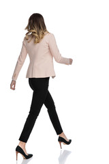 Fototapeta premium back view of confident businesswoman walking to side