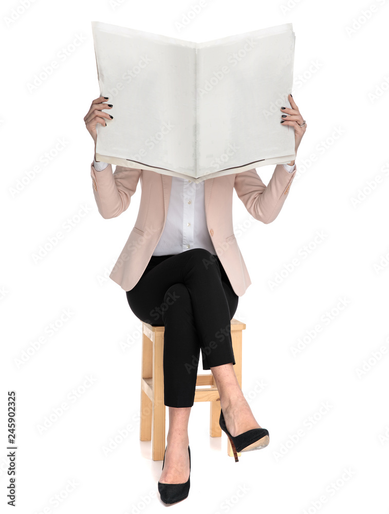 Poster smart casual woman reading the newspaper sits on wooden chair