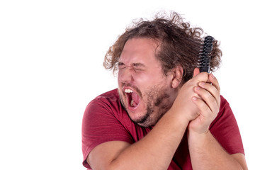 Close up portrait of fat man tries to comb his tangled and naughty hair with a small black comb...