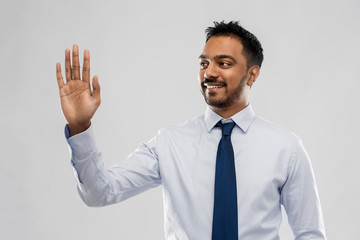 business, office worker and people concept - smiling indian businessman in shirt with tie working with virtual screen over grey background
