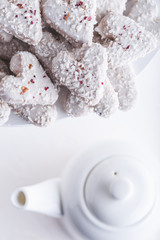  Valentine's day white coconut heart shaped cookies with red and pink heart sprinkles. Copy space