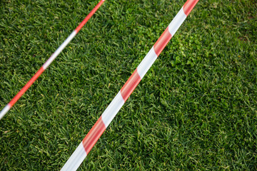 Fototapeta premium Barricade tape on the background of green grass