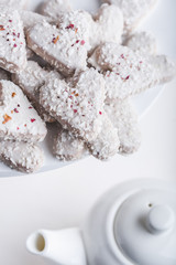  Valentine's day white coconut heart shaped cookies with red and pink heart sprinkles. Copy space