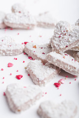  Valentine's day white coconut heart shaped cookies with red and pink heart sprinkles. Copy space
